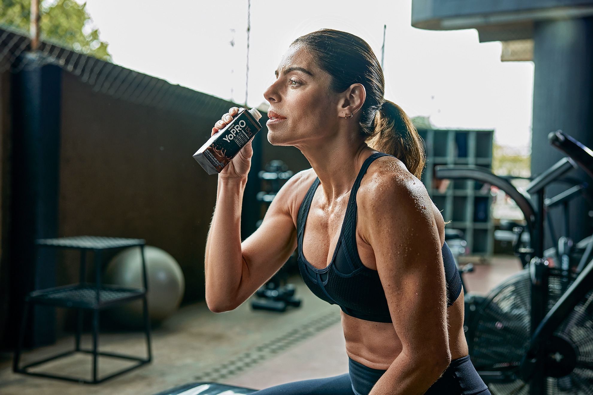 Mulher bebendo YoPRO após treino